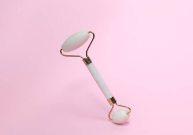 Pembe arka planda yeşim bir yüz silindiri. Güzellik konsepti.