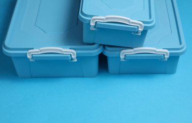 Mavi arka planda yiyecek depolamak için mavi plastik kaplar. Üst görünüm