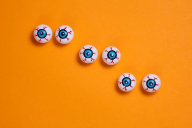 Turuncu arka planda gözler. Minimalist Cadılar Bayramı natürmort