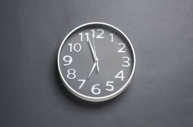 Koyu gri arkaplanda büyük yuvarlak duvar saati
