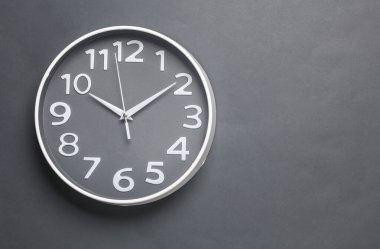 Koyu gri arkaplanda büyük yuvarlak duvar saati