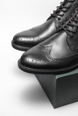 Yeni siyah deri erkek çizmeleri. Beyaz arka planda kutu var.