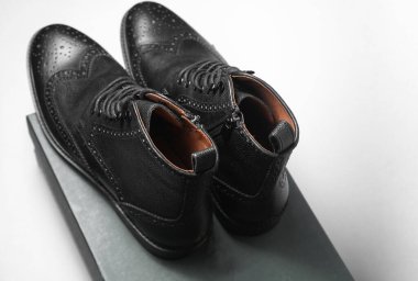 Yeni siyah deri erkek çizmeleri. Beyaz arka planda kutu var.