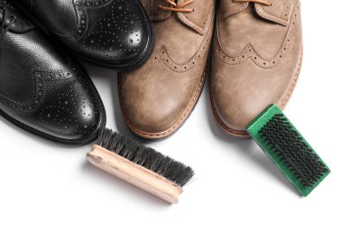 Beyaz arka planda fırçaları olan siyah akik ayakkabılar. Deri ayakkabılara dikkat.