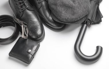 Beyefendinin aksesuarları. Erkek botları, kep ve şemsiye, kemer, beyaz arka planda cüzdan. Düz yatıyordu