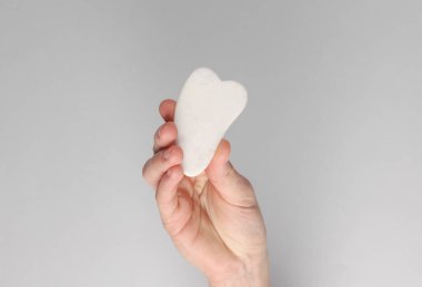 Gri arka planda beyaz yeşim taşlı kazıyıcı.