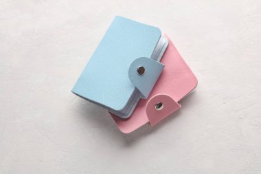 Beyaz beton arka planda mavi ve pembe deri kartvizit tutucu cüzdanları