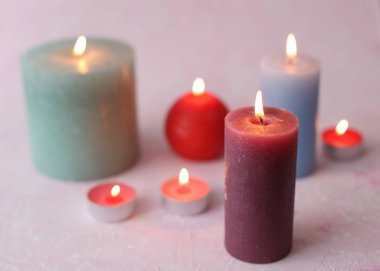 Pembe arka planda yanan mumlar. Romantik atmosfer