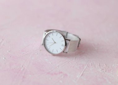 Pembe beton arka planda kadın kol saati