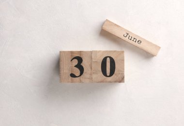 Ahşap blok takvimi beyaz beton zemin üzerine tarih 30 Haziran