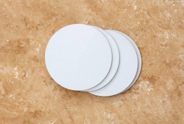 Altlık, bej beton arka planda beyaz yuvarlak modeller.