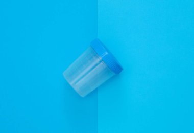 Mavi arka planda idrar testi kavanozu