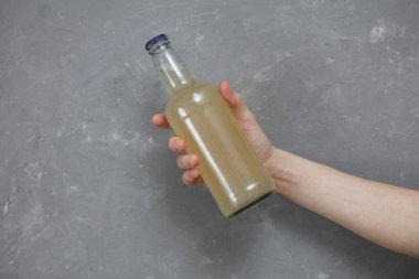 Gri beton arka planda hafif bira şişesi.