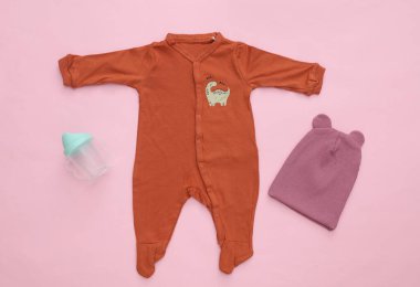 Pembe arka planda yeni doğmuş bebek kıyafetleri. Üst Manzara. Düz yatıyordu
