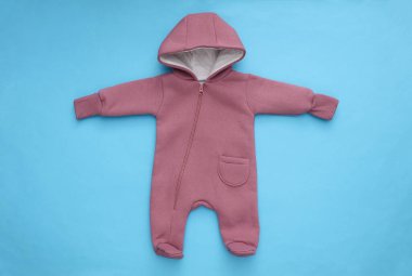 Mavi arka planda yeni doğmuş bebek kıyafetleri. Üst Manzara. Düz yatıyordu