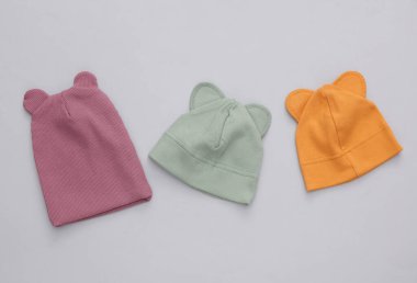 Gri arka planda bir grup çocuk şapkası.