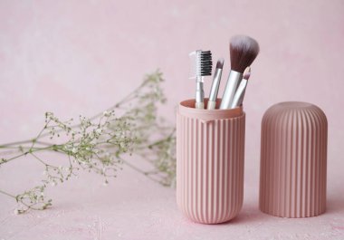 Depoda pembe beton arka planda makyaj fırçası seti