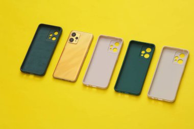 Sarı arka planda akıllı telefonlar için koruyucu davalar