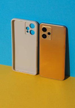 Beyaz koruyucu çanta ve mavi sarı arka planda akıllı telefon.