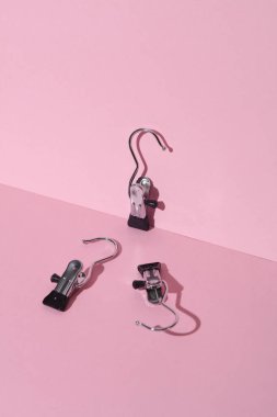 Pembe arka planda pantolon ve kot pantolon askıları