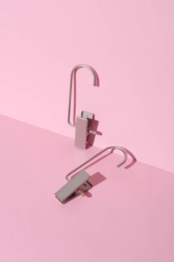 Pembe arka planda pantolon ve kot pantolon askıları