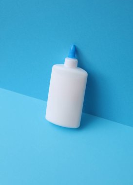 Mavi arka planda bir şişe pva yapıştırıcısı.