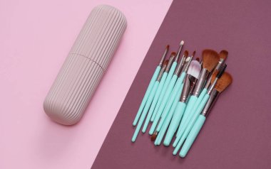 Pembe bordo arka planda depolama organizatörüyle makyaj fırçaları