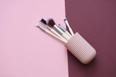Pembe bordo arka planda depolama düzenleyici çantasında makyaj fırçaları