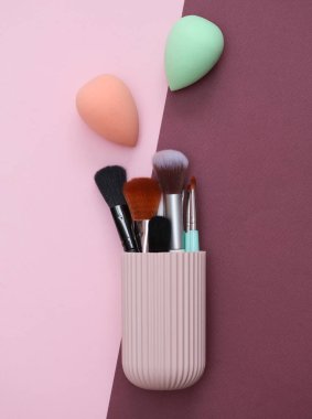 Pembe bordo arka planda makyaj aksesuarları olan organizatör davası