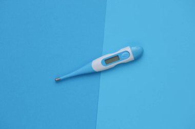 Mavi arka planda elektronik termometre. Üst görünüm