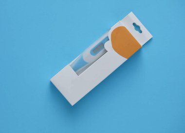 Mavi arkaplandaki bir kutuda yeni elektronik termometre