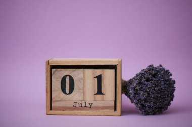 Tahta blok takviminde Temmuz 01 tarihi ve bir buket kuru lavanta