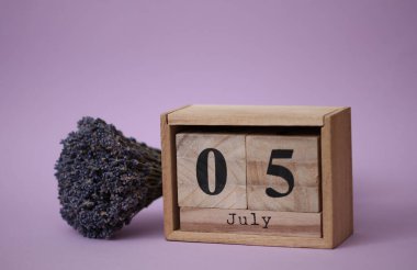 Tahta blok takvimi, tarihi Temmuz 05 ve bir buket kuru lavanta.