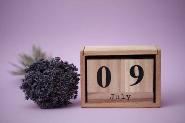 Tahta blok takvimi. Tarihi Temmuz 09 ve bir buket kuru lavanta.