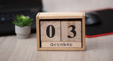 Tahta takvime göre tarih Ekim 03 bir masaüstünde dizüstü bilgisayarla