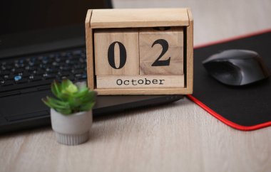 Tahta takvime göre tarih 02 Ekim. Bilgisayarlı bir masaüstü.