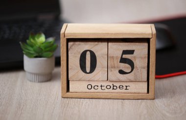 Tahta takvime göre tarih Ekim 05. Dizüstü bilgisayarı olan bir masaüstü.