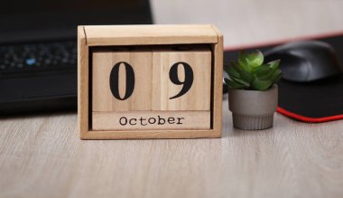 09 Ekim tarihli tahta takvim bir dizüstü bilgisayarın üzerinde