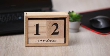 12 Ekim tarihli ahşap takvim bir dizüstü bilgisayarın üzerinde