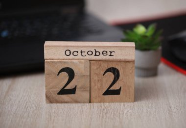 Masaüstünde tarihi 22 Ekim olan ahşap takvim.