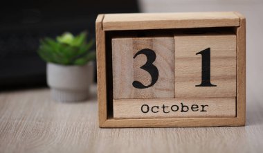 Masaüstünde 31 Ekim tarihli ahşap takvim.