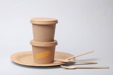 Yiyecek, ahşap tabak, çatal ve beyaz arka planda kaşık için eko karton kaplar. 