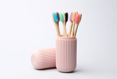 Eko bambu diş fırçaları beyaz arka planda plastik düzenleyici çantasında
