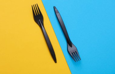 Mavi-sarı arkaplanda siyah plastik çatallar