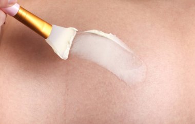 Hamile kadın karnına gerilme önleyici krem sürüyor.