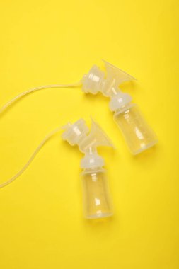 Sarı arka planda göğüs pompası şişeleri