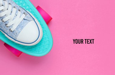 Pembe arka planda kaykaylı spor ayakkabılar. Minimalizm moda kavramı. Boşluğu kopyala