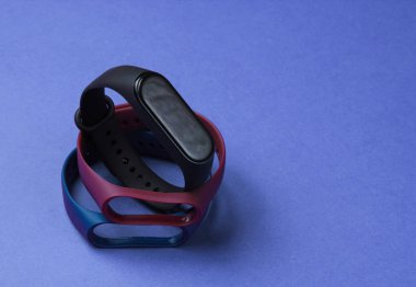 Mor arka planda değiştirilebilir bilezikleri olan akıllı saat. Fitness takip cihazı. Modern aygıtlar