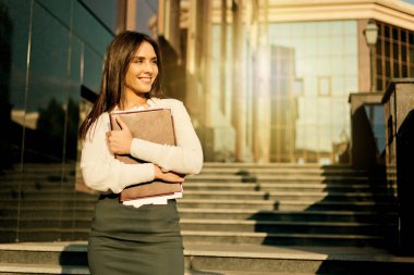 Bluzlu ve etekli çekici bir iş kadını klasör tutuyor. İş konsepti. Modern çalışma