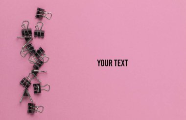 Pembe arka planda bir sürü ataç var. Minimalist ofis kavramı. Boşluğu kopyala